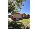 This exterior shows a well manicured lawn and desert landscaping with a brick accent and tile roof at 1827 E Carla Vista Dr, Gilbert, AZ 85295