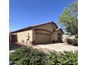 Exterior shot of a single-story home showcasing the garage and desert landscaping at 1827 E Carla Vista Dr, Gilbert, AZ 85295