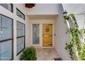 Inviting entryway featuring a decorative wooden door, side window, and elegant sconce lighting at 2132 E Northview Ave, Phoenix, AZ 85020