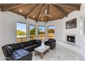 Bright living room with wood vaulted ceiling, fireplace, black leather seating, and marble floors at 2132 E Northview Ave, Phoenix, AZ 85020