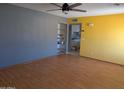 Bright living room with wood floors, a ceiling fan, and gray and yellow accent walls at 2179 E Palmcroft Dr, Tempe, AZ 85282