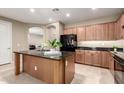 Spacious kitchen with a central island, black appliances and tan cabinets at 2507 E Eleana Ln, Gilbert, AZ 85298