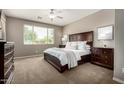 Calming main bedroom with a ceiling fan, two dressers, two night stands and a window at 2507 E Eleana Ln, Gilbert, AZ 85298