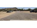 Long driveway leading to properties, parked cars, and desert landscape at 30940 N Varnum Rd, San Tan Valley, AZ 85143
