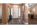 Inviting foyer features wood flooring, a large mirror, and views of an office space at 4020 W Menadota Dr, Glendale, AZ 85308