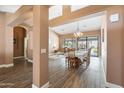 Open-concept living and dining area with wood floors, neutral paint, and a vaulted ceiling at 4020 W Menadota Dr, Glendale, AZ 85308