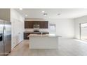 Bright kitchen features a large island, stainless steel appliances, and granite countertops at 42900 W Palo Amarillo Rd, Maricopa, AZ 85138