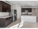 Modern kitchen with stainless steel appliances, granite countertops, a central island, and dark cabinetry at 42945 W Palo Amarillo Rd, Maricopa, AZ 85138