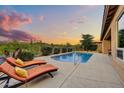 Backyard pool features lounge chairs, mature landscaping, and an iron fence, offering a private oasis at 5626 E Sleepy Ranch Rd, Cave Creek, AZ 85331