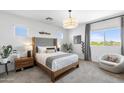 Bright bedroom with plush carpeting, a large window, and modern furnishings at 6338 W Raymond St, Phoenix, AZ 85043