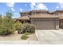 Two-story home with a large, attached garage, tile roof, and low-maintenance landscaping at 6338 W Raymond St, Phoenix, AZ 85043