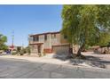 Inviting two-story home with a two-car garage and desert landscaping, enhanced by a mature tree at 7501 S 14Th St, Phoenix, AZ 85042