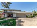 Two-story home features a red door, gray garage door, brick pathway, and manicured lawn at 8464 N 7Th Ave, Phoenix, AZ 85021