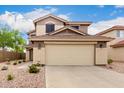 Well-kept two-story home showcasing a tan stucco exterior, tidy landscaping, and a spacious two-car garage at 864 S 223Rd Ln, Buckeye, AZ 85326