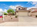 Inviting two-story home with manicured desert landscaping, a wide driveway, and a two-car garage at 864 S 223Rd Ln, Buckeye, AZ 85326