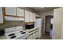 Functional kitchen with essential appliances, including a stove and refrigerator at 10408 W Devonshire Ave, Phoenix, AZ 85037