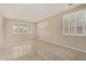 A well-lit living room with large windows, shutters, and tile flooring at 12023 W Duane Ln, Peoria, AZ 85383