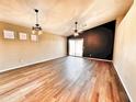 Spacious living room featuring wood floors, ceiling fans, recessed lighting and a modern dark accent wall at 1339 W Mesquite Ave, Apache Junction, AZ 85120