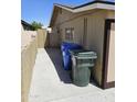 Exterior shot of the home's side yard, including garbage cans and a privacy wall at 13801 N 37Th Dr, Phoenix, AZ 85053