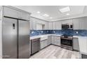 Modern kitchen featuring stainless steel appliances and stylish blue backsplash at 14224 N Newcastle Dr, Sun City, AZ 85351