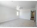 Spacious bedroom with a ceiling fan, neutral carpet, and a window offering ample natural light at 16159 W Maui Ln, Surprise, AZ 85379