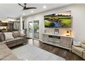 Bright living room features a comfy couch, ceiling fan, and a large TV at 16202 N 61St Ave, Glendale, AZ 85306