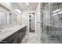 Bathroom with marble floors, dual sinks, and a glass enclosed shower with tile surround at 1712 E Joelle Dr, Casa Grande, AZ 85122