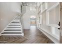 Grand foyer with high ceilings, modern staircase, and custom wall decor at 1712 E Joelle Dr, Casa Grande, AZ 85122