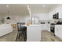 Stylish kitchen with stainless steel appliances, a center island with seating and pendant lighting at 17557 W Victory St, Goodyear, AZ 85338