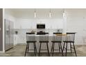 Bright kitchen featuring white cabinetry, stainless steel appliances, and a spacious center island at 17557 W Victory St, Goodyear, AZ 85338