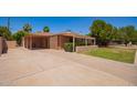 Single-Gathering home with attached carport and desert landscaping on a sunny day at 1810 N 74Th St, Scottsdale, AZ 85257