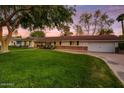 Traditional home with brick accents, a wide driveway, and a well-manicured lawn at 1831 E Rovey Ave, Phoenix, AZ 85016