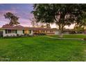 Landscaped front yard with green lawn, mature trees, and a welcoming facade at 1831 E Rovey Ave, Phoenix, AZ 85016