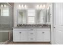 Bathroom with double sinks, modern fixtures, decorative mirror, and a glass shower at 1848 S Follett Way, Gilbert, AZ 85295