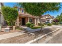 Beautiful two-story home with a cozy front porch, complemented by lush greenery and a manicured lawn at 2048 S Martingale Rd, Gilbert, AZ 85295