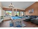 Spacious game room with a pool table, large windows, and a comfortable sitting area at 22634 N 47Th Pl, Phoenix, AZ 85050