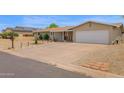 Exterior of the home featuring a two-car garage and desert-style landscaping with charming porch at 301 N 87Th St, Mesa, AZ 85207