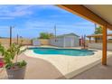 Backyard view of a refreshing private pool surrounded by a concrete deck and an outbuilding at 301 N 87Th St, Mesa, AZ 85207
