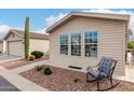 Charming single-story home with desert landscaping, a rocking chair, and large windows at 3301 S Goldfield Rd # 1046, Apache Junction, AZ 85119