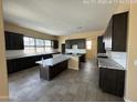 Spacious kitchen featuring two islands with granite countertops, gray cabinets and tile flooring at 359 N 157Th Ln, Goodyear, AZ 85338