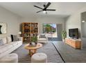 Bright living room with tile flooring, neutral decor, and sliding doors to the back patio at 37711 W Bello Ln, Maricopa, AZ 85138