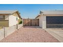 A large fenced driveway leading to an attached garage and back alley access at 4549 W Poinsettia Dr, Glendale, AZ 85304