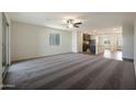 Spacious living room with a ceiling fan flowing seamlessly into the modern kitchen, perfect for entertaining at 551 S West Virginia Ave, Florence, AZ 85132