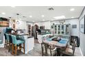 Open-concept kitchen and dining area featuring modern white cabinetry, granite countertops, and stainless steel appliances at 6219 N 22Nd Dr, Phoenix, AZ 85015