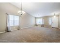 Spacious living room featuring high ceilings, carpet floors, and natural light from large windows at 637 E Settlers Trl, Casa Grande, AZ 85122