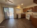 Bright kitchen features dark cabinetry, granite countertops, white appliances, and sliding door at 7905 W Thunderbird Rd # 307, Peoria, AZ 85381