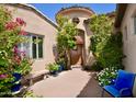 Charming front entry with a courtyard, lush plants, and a custom wood door at 9842 E Celtic Dr, Scottsdale, AZ 85260