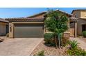Inviting home featuring a two-car garage, neutral exterior, and low maintenance landscaping with gravel and greenery at , Avondale, AZ 85323