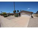 Well-kept single-level home with a two-car garage and a basketball hoop on the driveway at 10858 E Sahuaro Dr, Scottsdale, AZ 85259