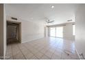 Bright living room featuring tile floors, a ceiling fan, and a sliding glass door leading to the backyard at 10858 E Sahuaro Dr, Scottsdale, AZ 85259